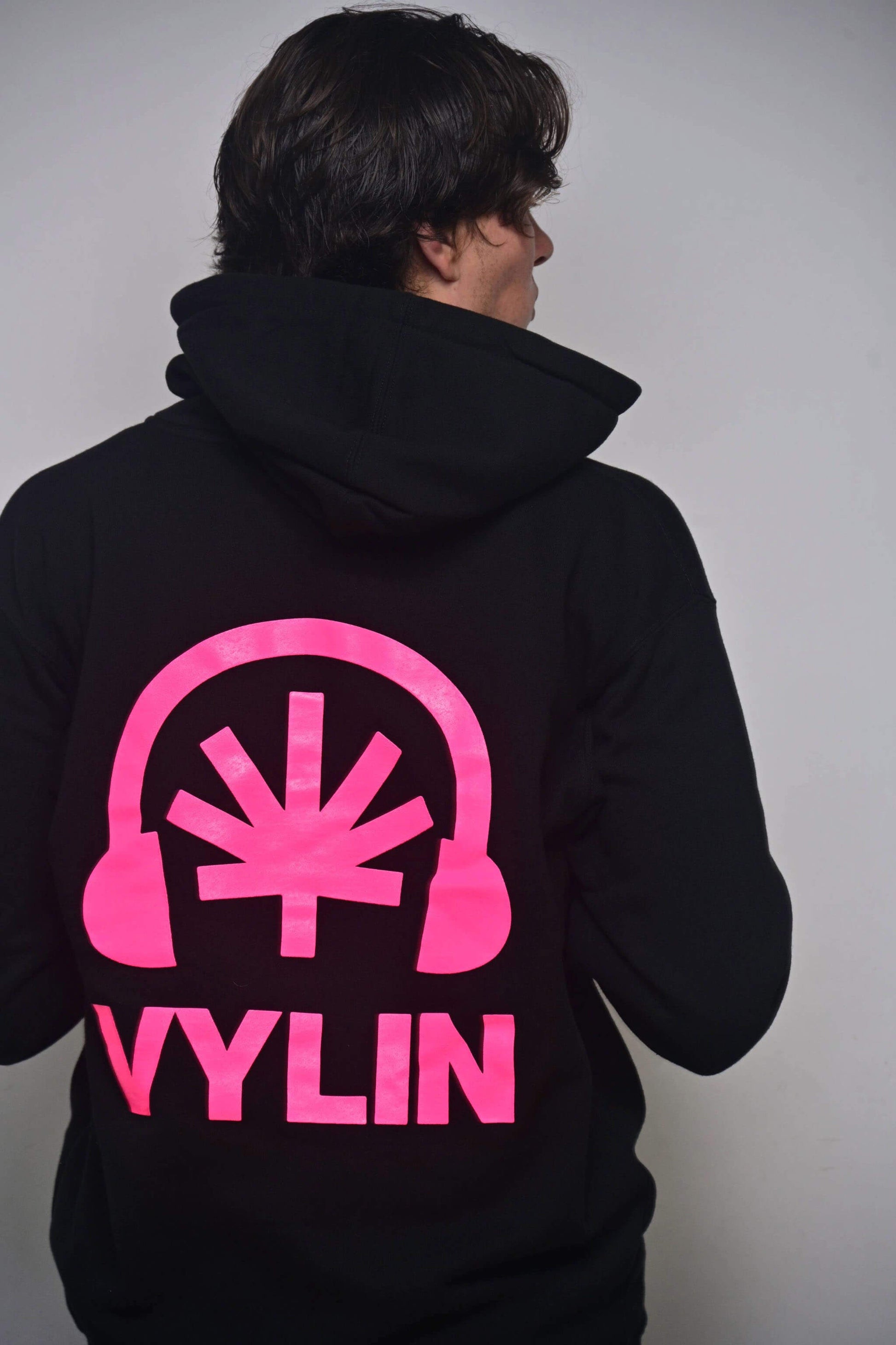 Black zip hoodie with oversized hot pink Headphones + stylized cannabis leaf + VYLIN word mark back graphic (back, on-model)