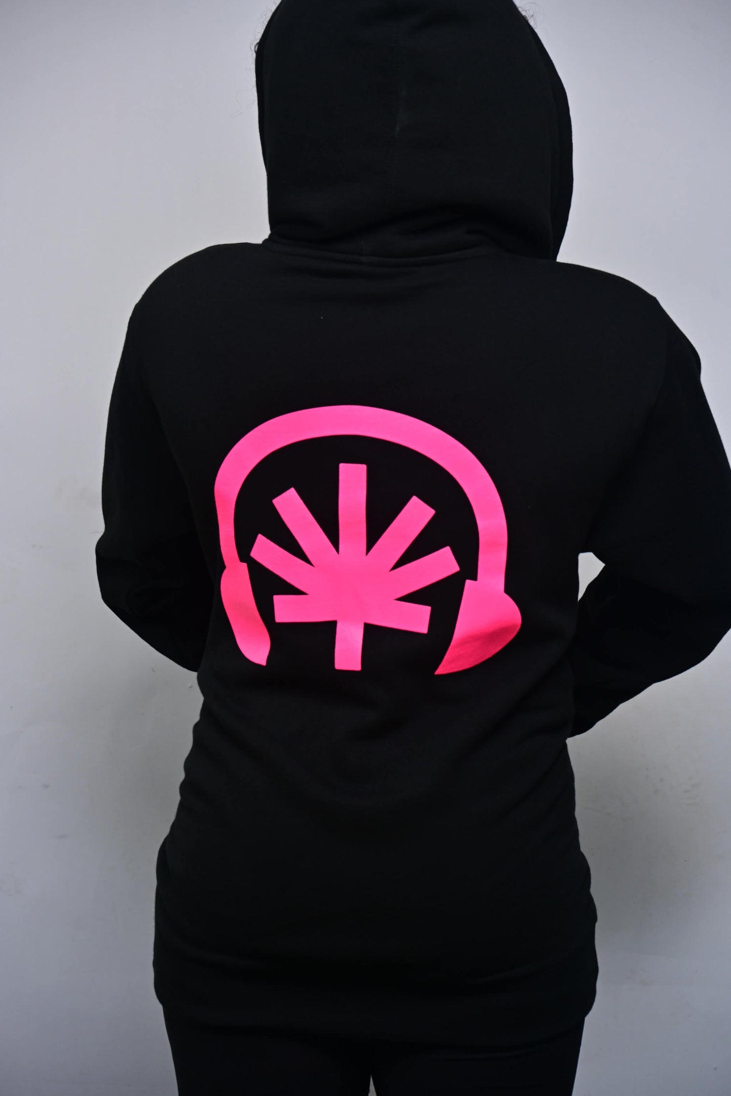 VYLIN black zip hoodie with oversized hot pink headphones + stylized leaf back print (on-model back view)
