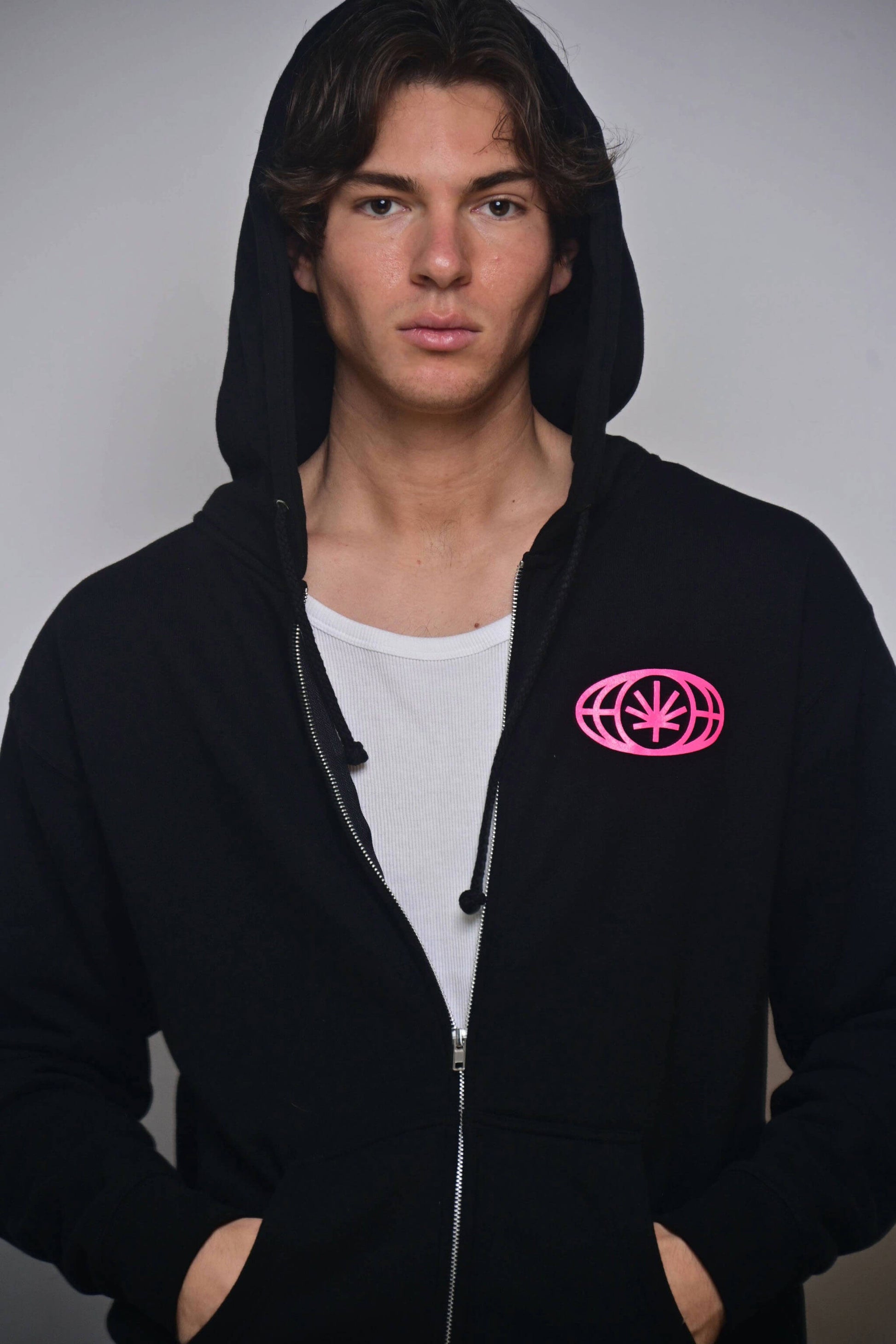VYLIN black zip hoodie with small hot pink chest emblem (on-model front view)